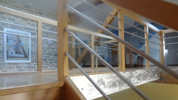 A wooden staircase with metal railings leading to a lofted area with a glass wall. - Spacious, well-equipped, in a breathtaking setting (Mournans-Charbonny)