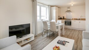 Un appartement moderne comprenant un salon, un coin repas et une cuisine.