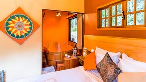 A room with a bed, a wooden bathtub, and a window with a view of trees. - Amadamata Refúgio Ecológico (Nova Friburgo)