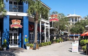 Ein Restaurant direkt am Strand mit Außenbestuhlung und Palmen.
