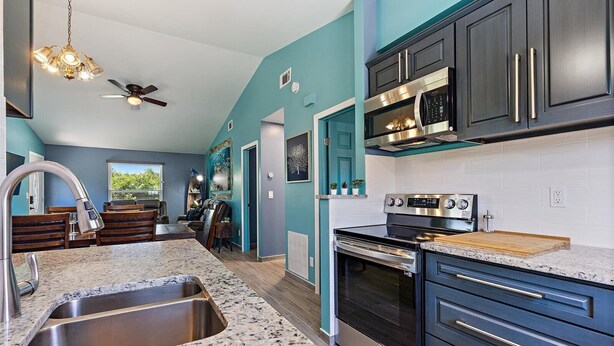 A modern kitchen with dark cabinets, stainless steel appliances, and a granite countertop. - Newly renovated, cozy 2 bedroom.  (Englewood)