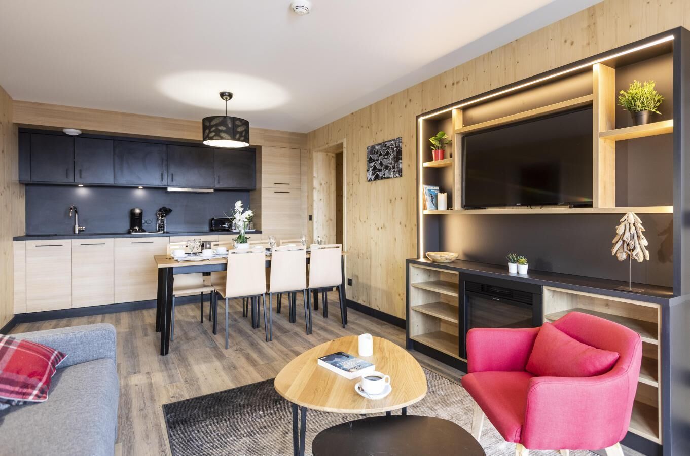 A modern living space with a kitchen, dining area, and seating area.