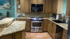 A kitchen with wooden cabinets, a stainless steel oven, a microwave, and a dishwasher.