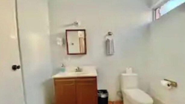 A small bathroom with a toilet, sink, and cabinet. - Lorena - Amazing Ocean View! (Heroica Guaymas)