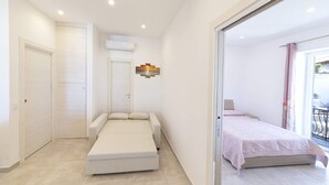 Ein modernes Schlafzimmer mit Bett, Sofa und Balkon.