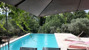 A swimming pool with a view of surrounding trees, a covered patio area with chairs, and a table. - Villa with private pool (secure) pétanque court-Mont Ventoux - Last minute (Modène)