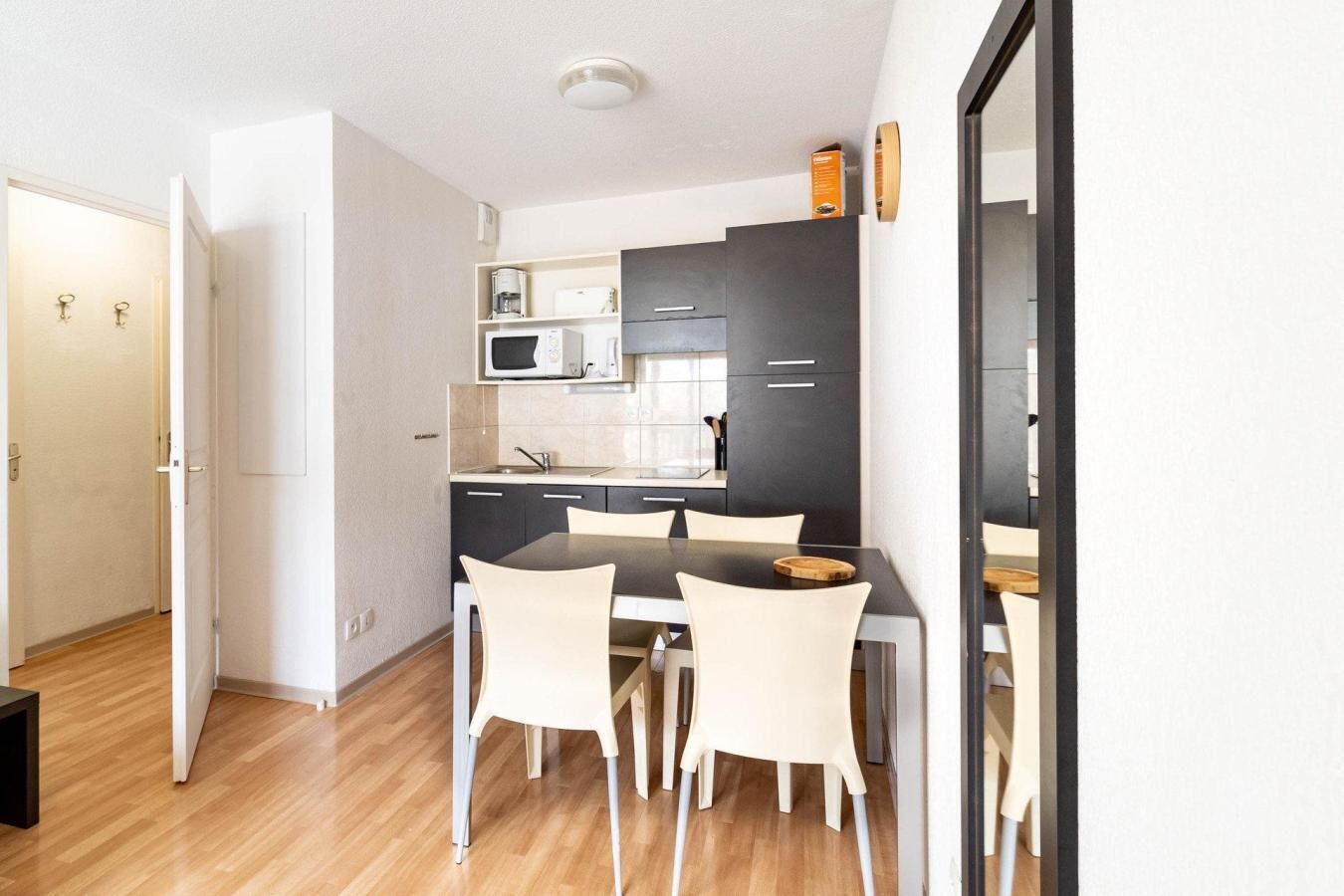 A compact kitchen with a dining area, featuring a microwave, stove, and cabinets.