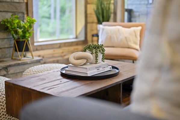 Una mesa de madera con una bandeja que contiene libros y una pequeña planta.