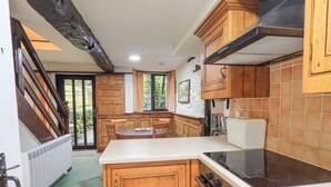 Eine Küche mit Holzschränken, einer weißen Arbeitsplatte und einem eingebauten Backofen.