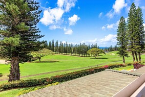 A golf course with a clear sky, green grass, and tall trees. - New Listing! Gorgeous Spacious Tropical Oasis (Lahaina)