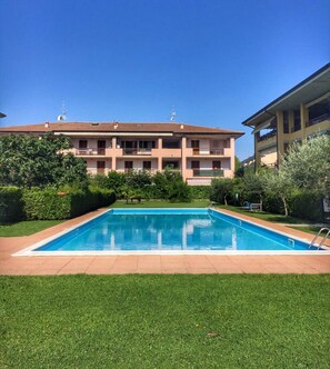 Un bâtiment à deux étages avec une piscine devant.