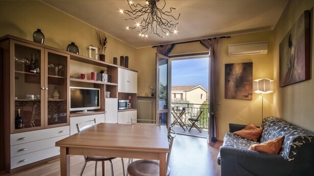 Ein moderner Wohnbereich mit Essbereich, einer Couch und einem Balkon mit Aussicht.