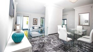 A modern living room with a glass coffee table, white sofas, and a large mirror. - Villa Patrizia Lake View - Italian Homing (Desenzano del Garda)