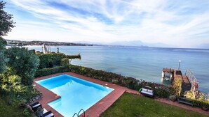 A swimming pool with a view of a lake and distant mountains. - Villa Patrizia Lake View - Italian Homing (Desenzano del Garda)