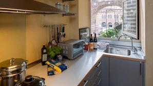 A modern kitchen with a view of a historic building through the window. - Residenza Dei Signori - Italian Homing (Verona)