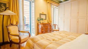A bedroom with a large bed, two chairs, a dresser, and a window with curtains. - Residenza Dei Signori - Italian Homing (Verona)