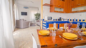 A modern kitchen with blue and yellow tiles, wooden cabinets, and a dining area set for a meal. - The Secret Garden - Italian Homing (Padenghe sul Garda)