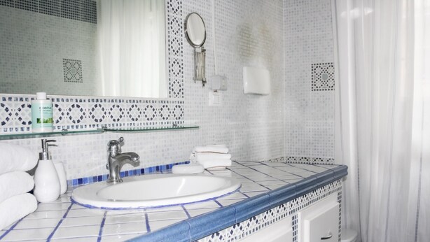 A bathroom with a white sink, blue-tiled countertop, and a mirror. - The Secret Garden - Italian Homing (Padenghe sul Garda)