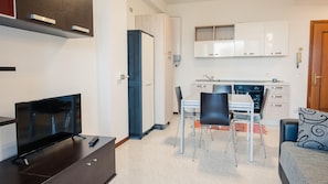 Cozy living space with a kitchenette, flat-screen TV, and dining area.