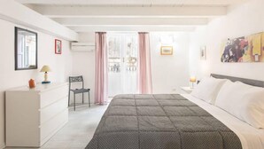 Une chambre à coucher avec un lit, une chaise, un bureau et une fenêtre avec des rideaux.