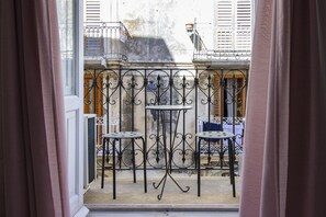 A balcony with wrought iron railings and two small tables. - Sr-i754-cman47a1 - Maniace Homes - Federico Apartment (Syracuse)
