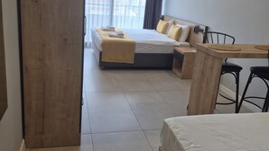 Een hotelkamer met een bed, bureau, stoel en een groot raam.