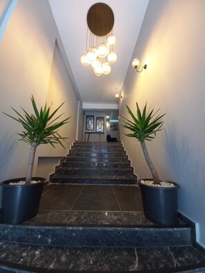 A staircase with two potted plants on either side, leading to a door at the top. - Likya 202 (Demre)