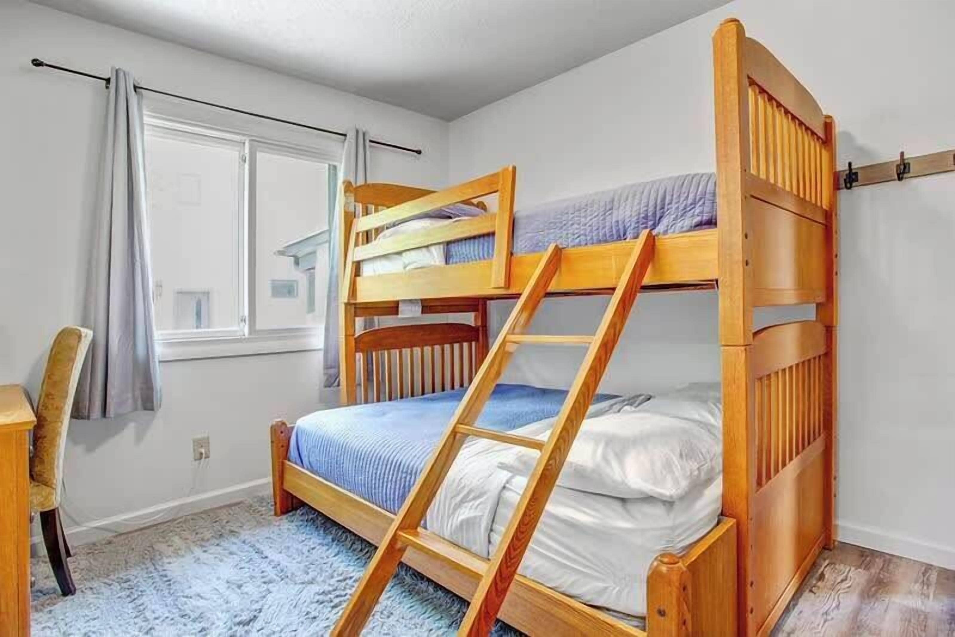 This bunk bed includes a double bed on the bottom and a twin bed on top, plus a workspace. 