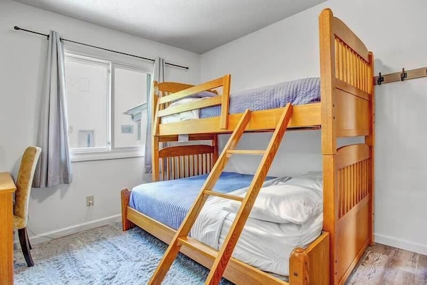 This bunk bed includes a double bed on the bottom and a twin bed on top, plus a workspace.