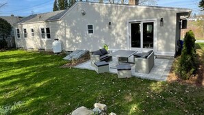A modern house with a patio area featuring outdoor furniture.