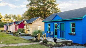 A row of colorful cabins with individual porches and small steps leading to the entrance. - Tiny House close to the Beaches of Cape Charles (Cape Charles)