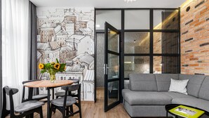 Un salon moderne comprenant un coin repas, un canapé gris et une table avec un livre.