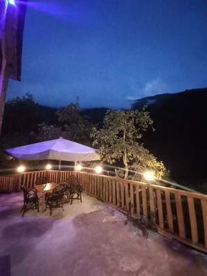 An outdoor patio with a table and chairs, a wooden fence, and a tree. - Ladin Dag Evi (Camlihemsin)