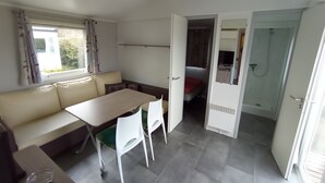 Ein kleines Zimmer mit einer Couch, einem Tisch und einer Tür zu einem Badezimmer.