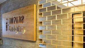 Un panneau en bois portant l’inscription « Horizon Lodge » et un mur composé d’une grille de fenêtres.