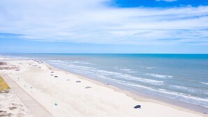 A beach with a sandy shore and calm sea.