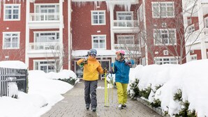 Un bâtiment en briques rouges, doté de nombreuses fenêtres et de balcons, entouré de neige.
