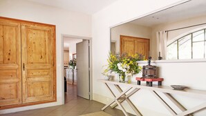 Une cuisine avec des meubles en bois, un plan de travail blanc et un miroir au-dessus.