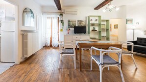 Una cocina moderna con armarios blancos, una mesa de comedor de madera y sillas blancas.