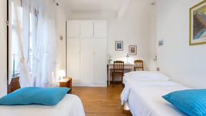Un dormitorio con dos camas, un escritorio y una silla.