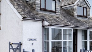 Ein Gebäude mit weißer Fassade, einem Stehendach und einem Schild mit der Aufschrift 'LAMORNA 2'.