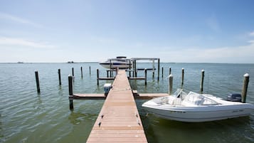 A wooden pier extending into calm water with a boat docked at the end.