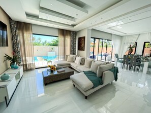 A modern living room with a sofa, coffee table, and dining area.