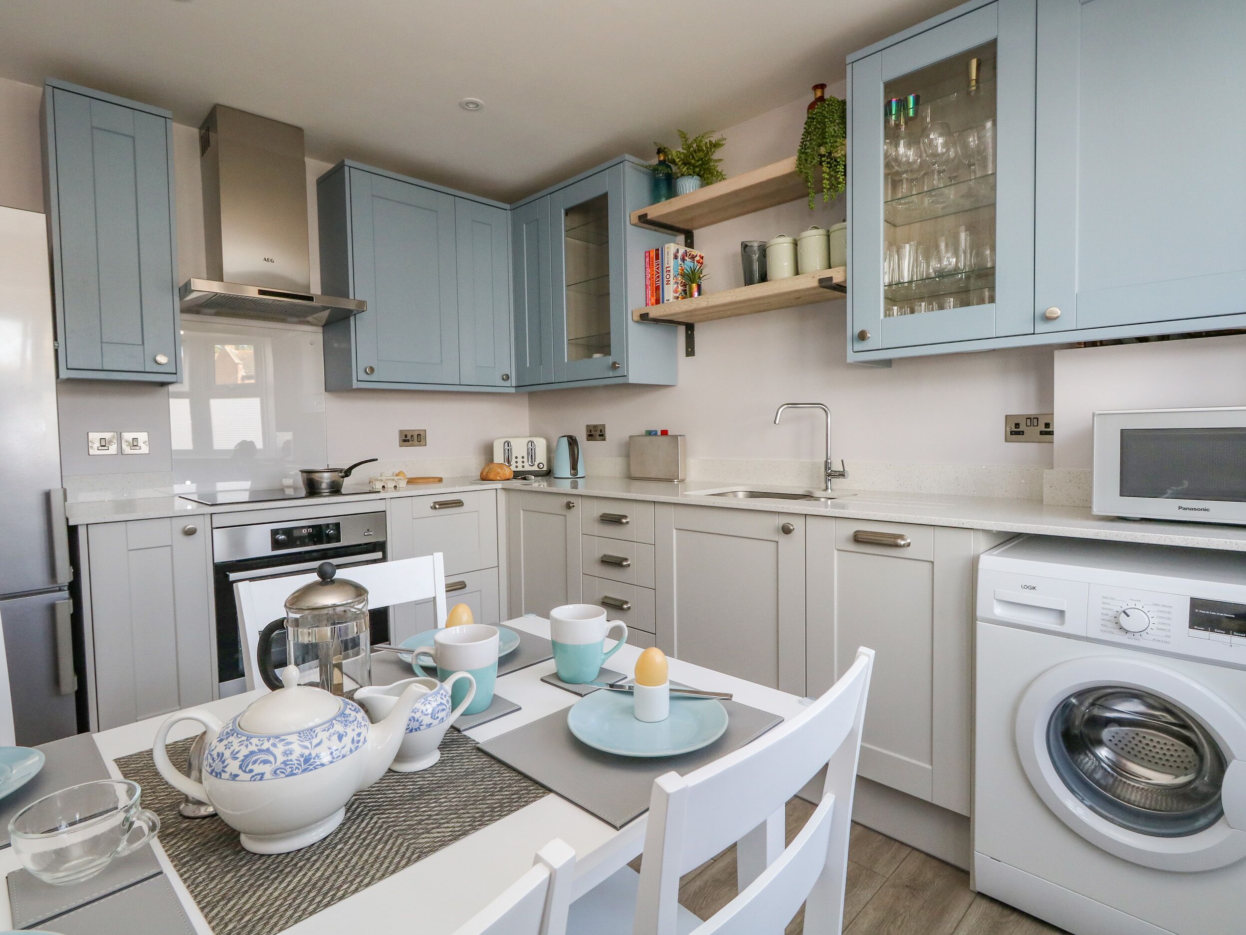 A compact kitchen with a microwave, oven, and washing machine.