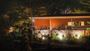 Un bâtiment doté d’un espace extérieur couvert, qui pourrait être un restaurant ou un café, avec des tables et des chaises.