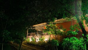 Un bâtiment doté d’un espace extérieur abrité, entouré d’une végétation luxuriante.