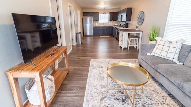 A modern living room with a flat-screen TV, wooden coffee table, and grey sofa. - 2BR Private Suite w/ Full Kitchen & Laundry! (Meadow Lakes)