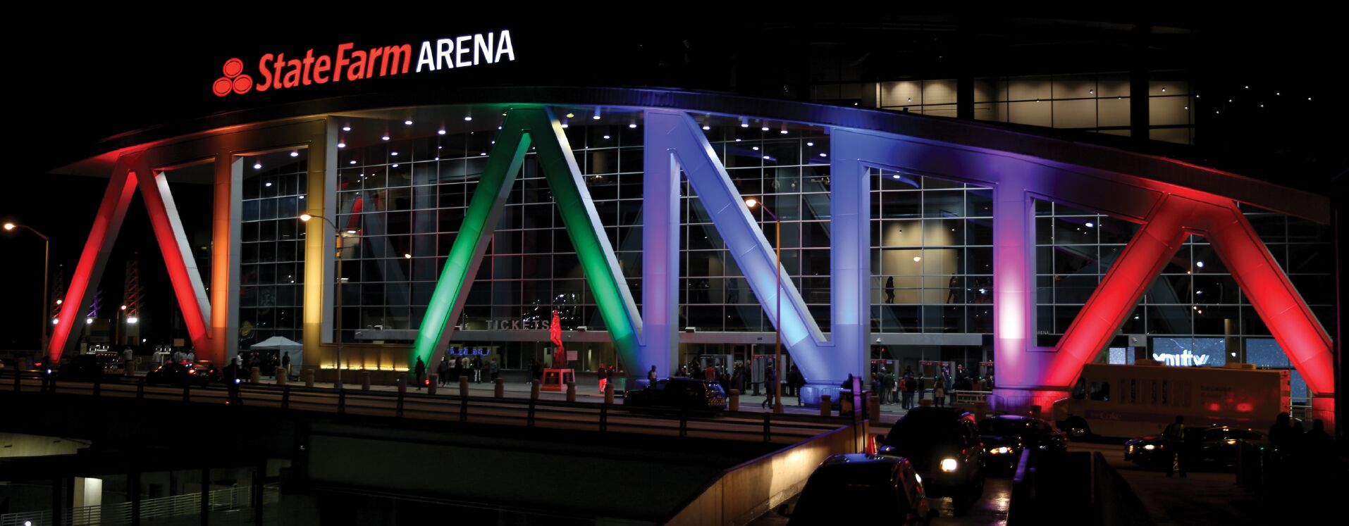The State Farm Arena with a modern design, featuring large glass windows and a distinctive roof structure.