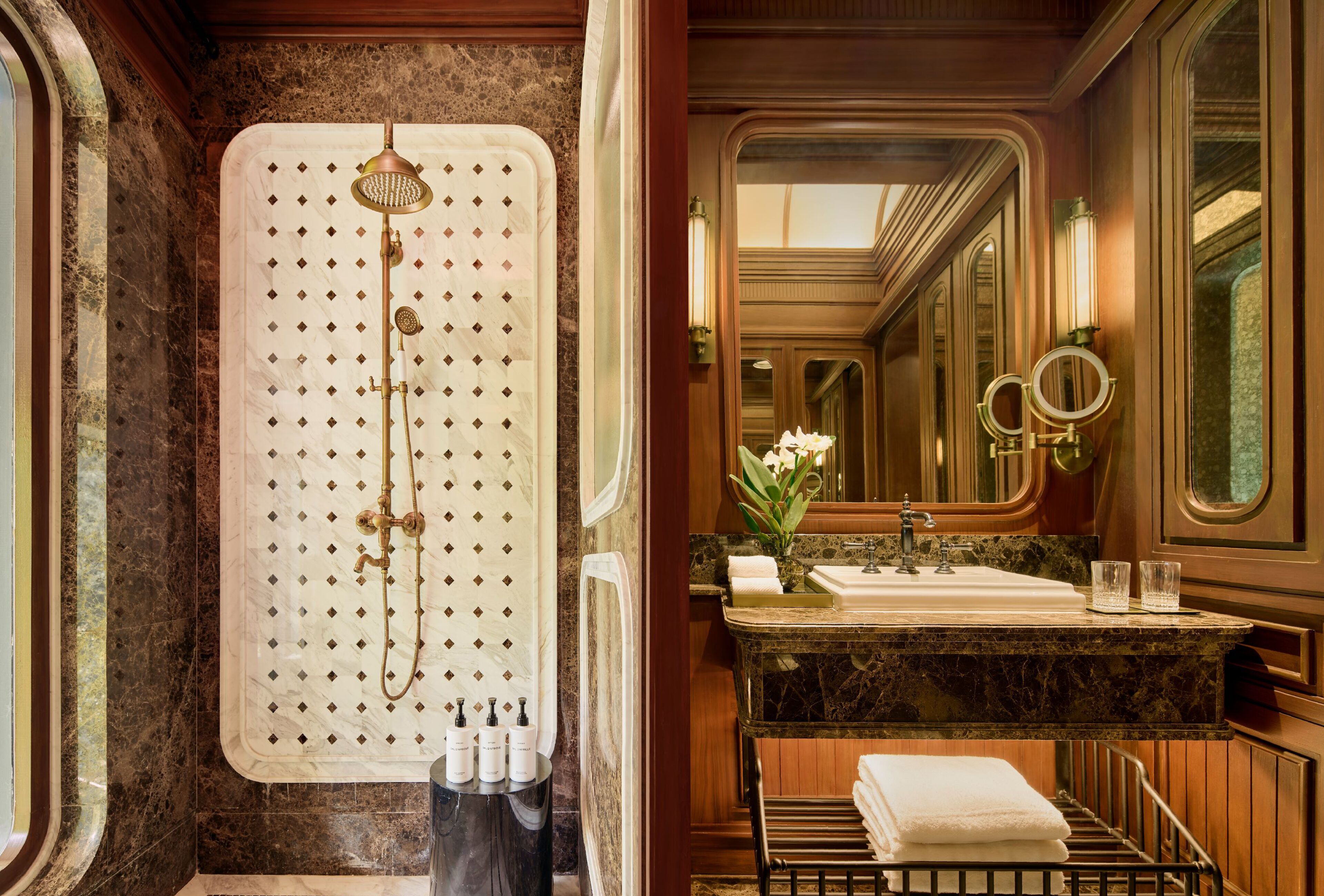 A luxurious bathroom with a freestanding shower, marble countertops, a vanity with a sink, and a large mirror.