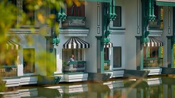Un edificio tradicional con un balcón y su reflejo en el agua.